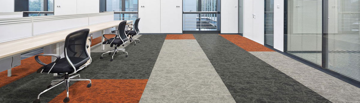 Osaka Range of Carpet tiles in desk Work area of office. In multiple patterned colours of orange, dark greys and light greys 
