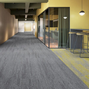 Burmatex Threads range of carpet tiles in shades of yellow and grey within open office with long corridor